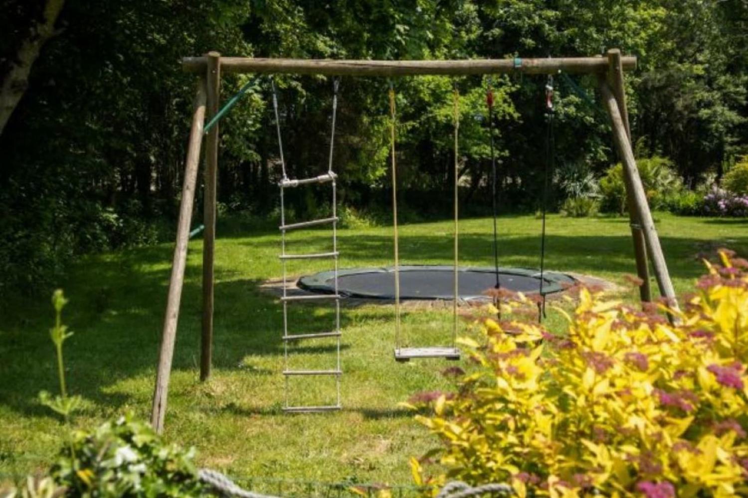 Balançoires et trampoline dans le jardin